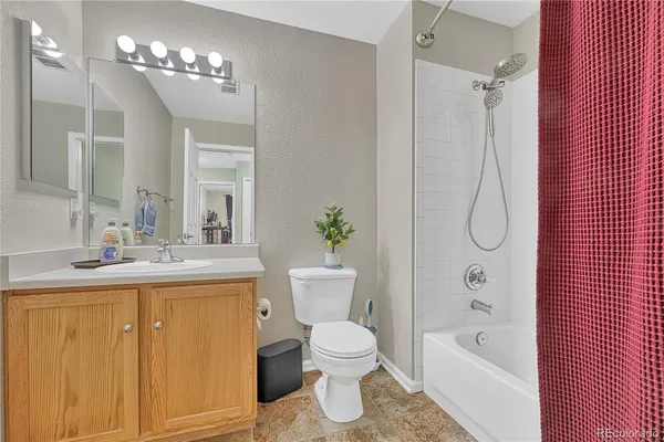 a bathroom with a granite countertop sink a toilet and a bathtub