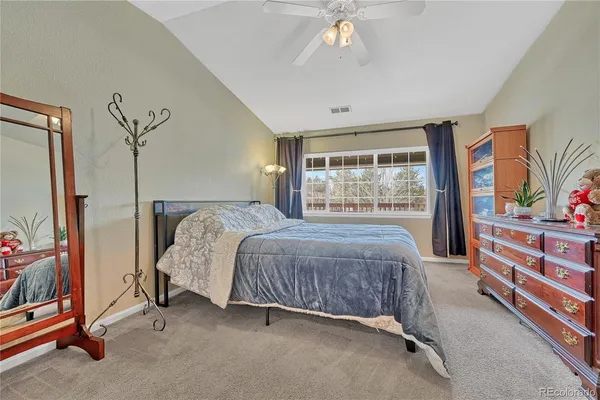 a bedroom with a bed and a dresser next to a window