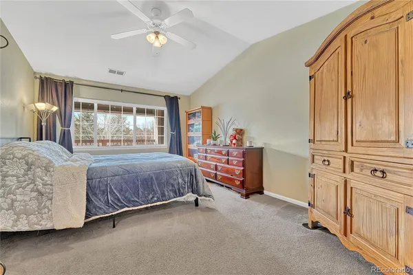 a spacious bedroom with a bed and a chandelier