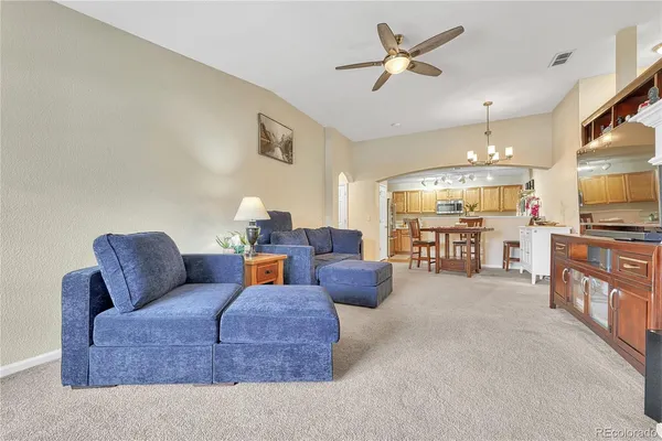 a living room with furniture and a flat screen tv with kitchen view