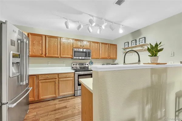 a kitchen with stainless steel appliances granite countertop a refrigerator a stove top oven a sink and dishwasher