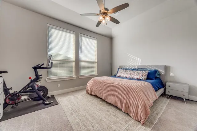 a bedroom with a bed a couch and a ceiling fan