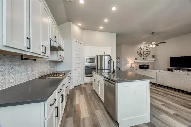 a kitchen with stainless steel appliances granite countertop a sink stove and refrigerator