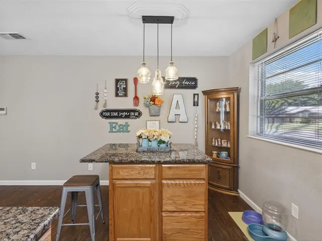a room with kitchen island stainless steel appliances a sink and a window
