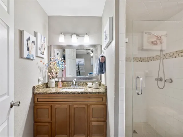 a bathroom with a sink vanity and shower