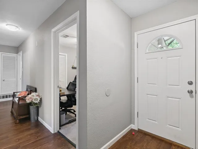 a view of a hallway with wooden floor and closet