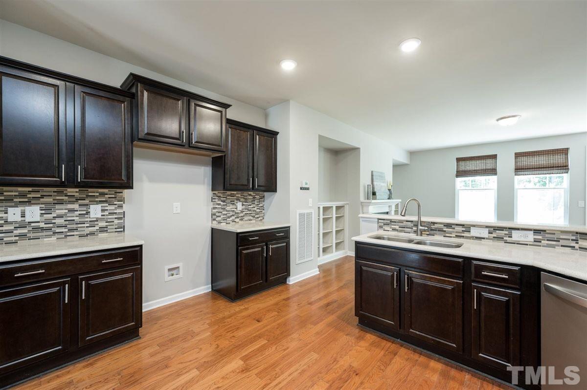 715 Edgewater Ridge Court Apex, NC 27523 - Photo 9 of 29 The kitchen flows directly in the family room. An entertainers dream! Don't miss the bar-height area around the edge of this kitchen for those causal meals.