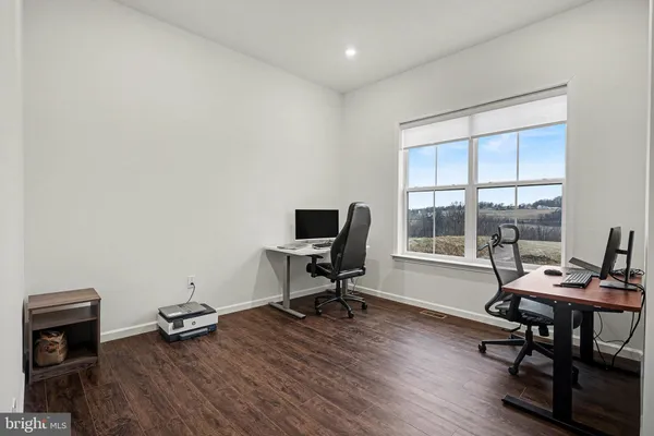 a view of a workspace with furniture and a window