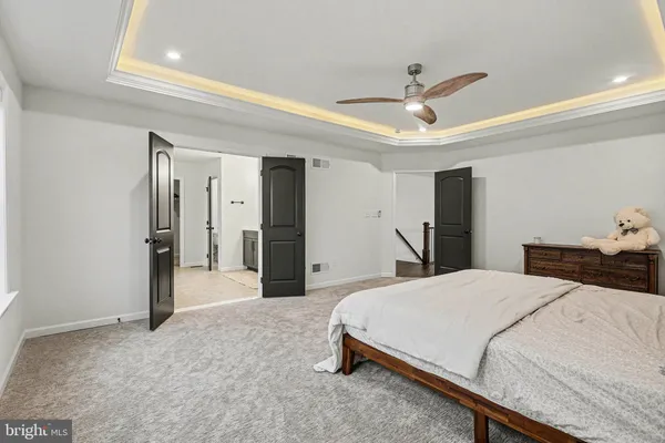 a room with a bed and ceiling fan