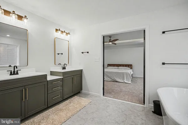 a spacious bathroom with a double vanity sink a mirror and shower