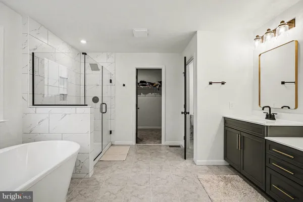 a bathroom with a tub sink and mirror