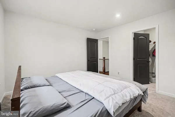 a bedroom with a bed and a refrigerator
