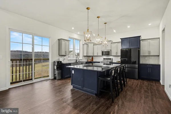 a kitchen with kitchen island granite countertop wooden floors and cabinets