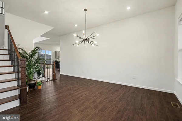 a view of a room with wooden floor potted plants and a ceiling fan