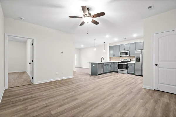 a kitchen with a sink chandelier and wooden floor