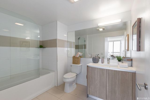 a bathroom with a bathtub shower sink vanity and toilet