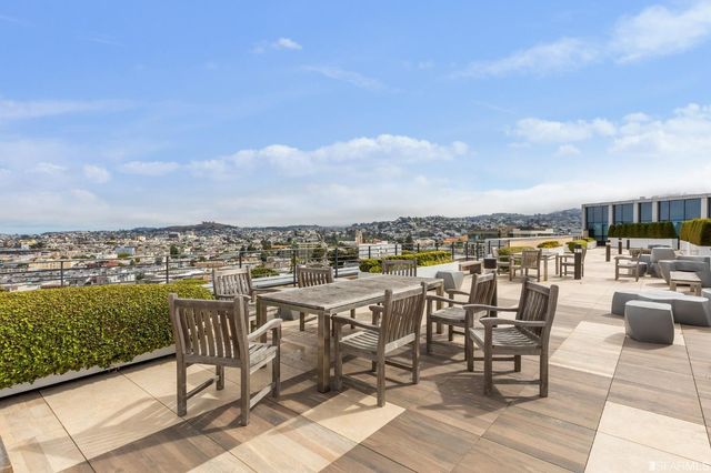 a view of a terrace with furniture and city view