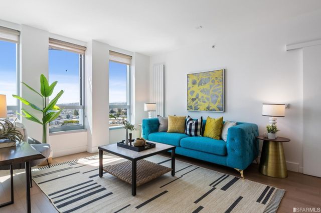 a living room with furniture a lamp a rug and a window