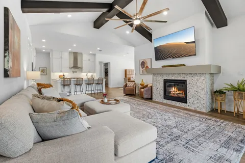 a living room with furniture a fireplace and a flat screen tv