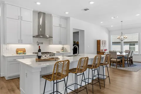 a kitchen with stainless steel appliances granite countertop a table and chairs in it