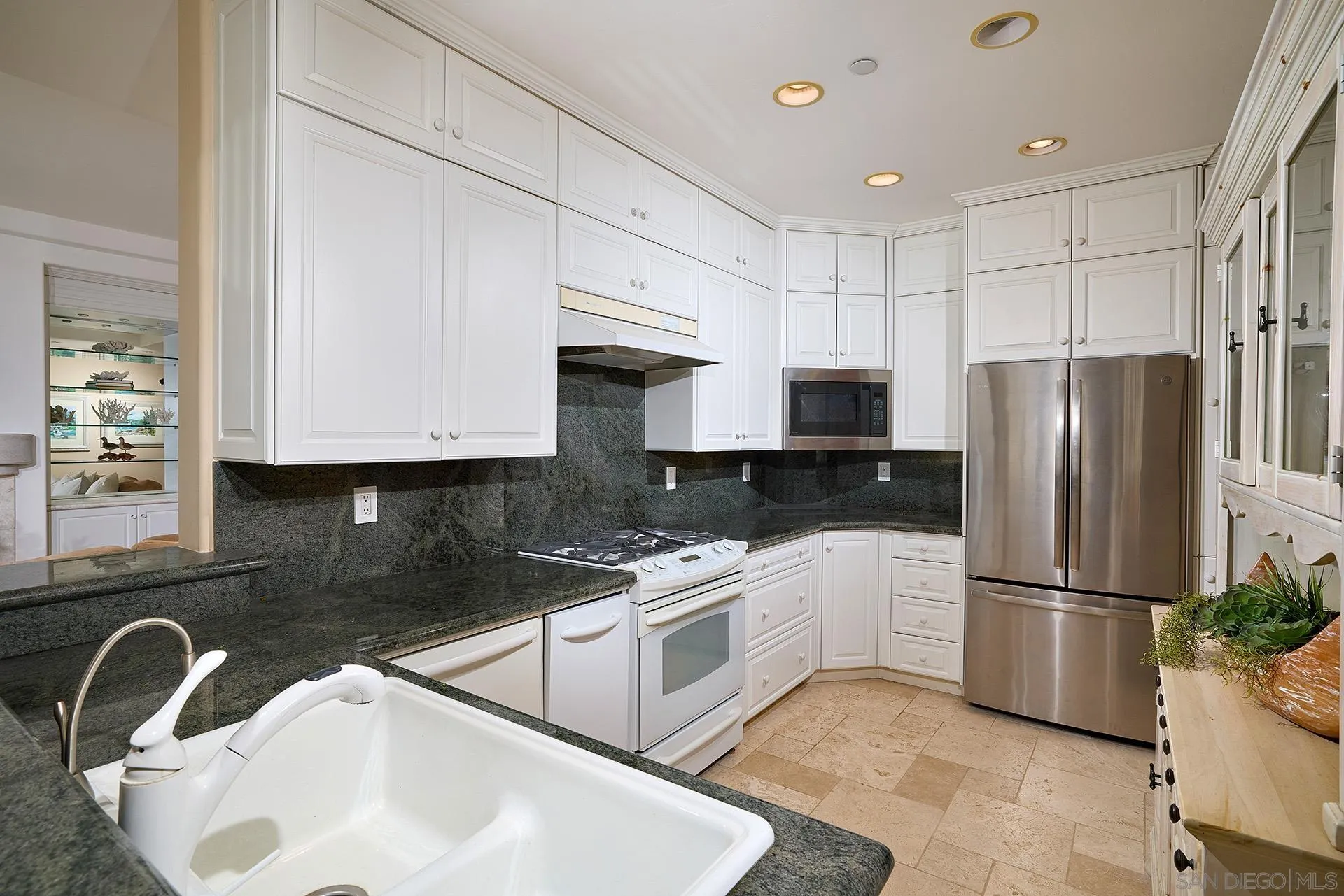 1630 Neptune Avenue Encinitas, CA 92024 - Photo 8 of 25 a kitchen with a sink a refrigerator and cabinets