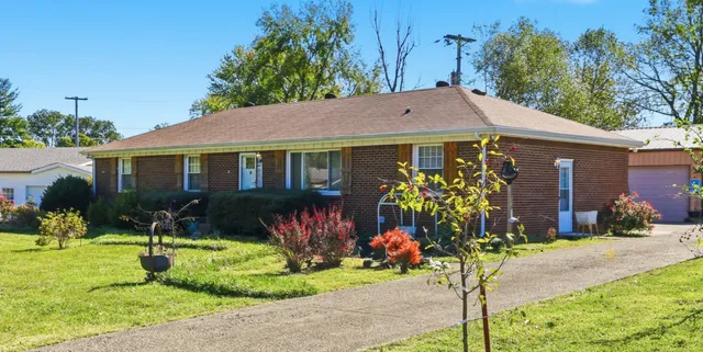 a front view of a house with a yard and a garden
