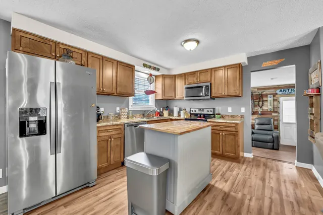 a kitchen with stainless steel appliances granite countertop a refrigerator stove and sink
