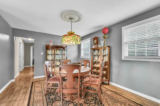 a view of a dining room with furniture a chandelier and wooden floor