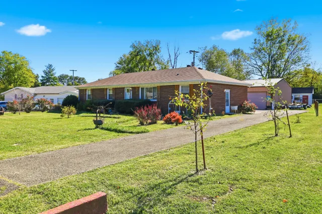 a view of a house with backyard and sitting area