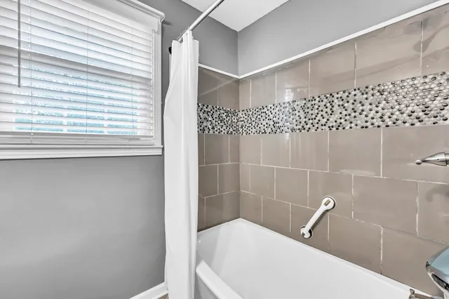 a bathroom with a bathtub and shower