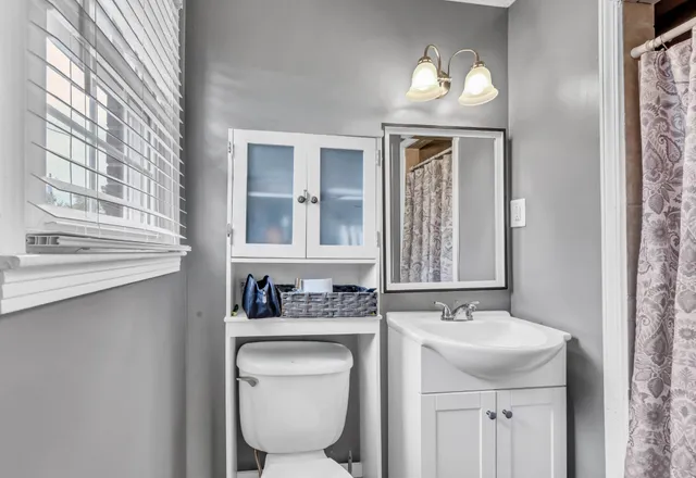 a bathroom with a toilet sink and mirror