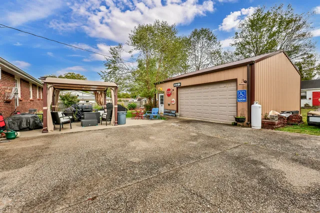 a view of a house with a patio and a yard