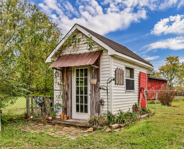 a view of a house with a big yard and large trees