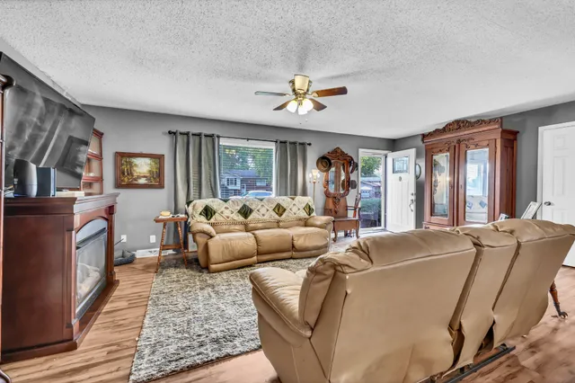 a living room with furniture ceiling fan and a rug