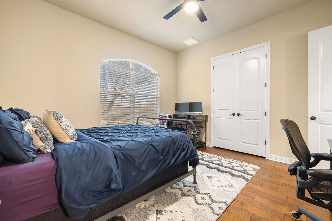 103 Kendall Road Spicewood, TX 78669 - Photo 23 of 37 a bedroom with a bed a desk and chair
