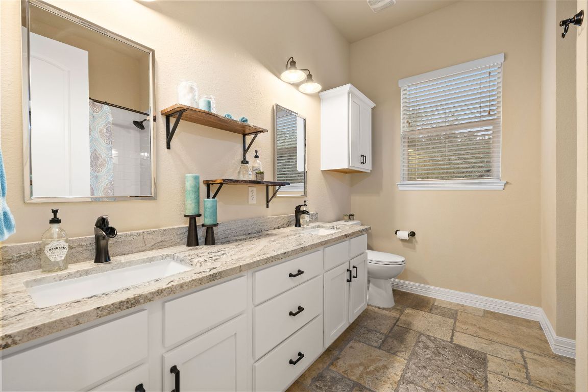 103 Kendall Road Spicewood, TX 78669 - Photo 25 of 37 a bathroom with a granite countertop sink mirror and a