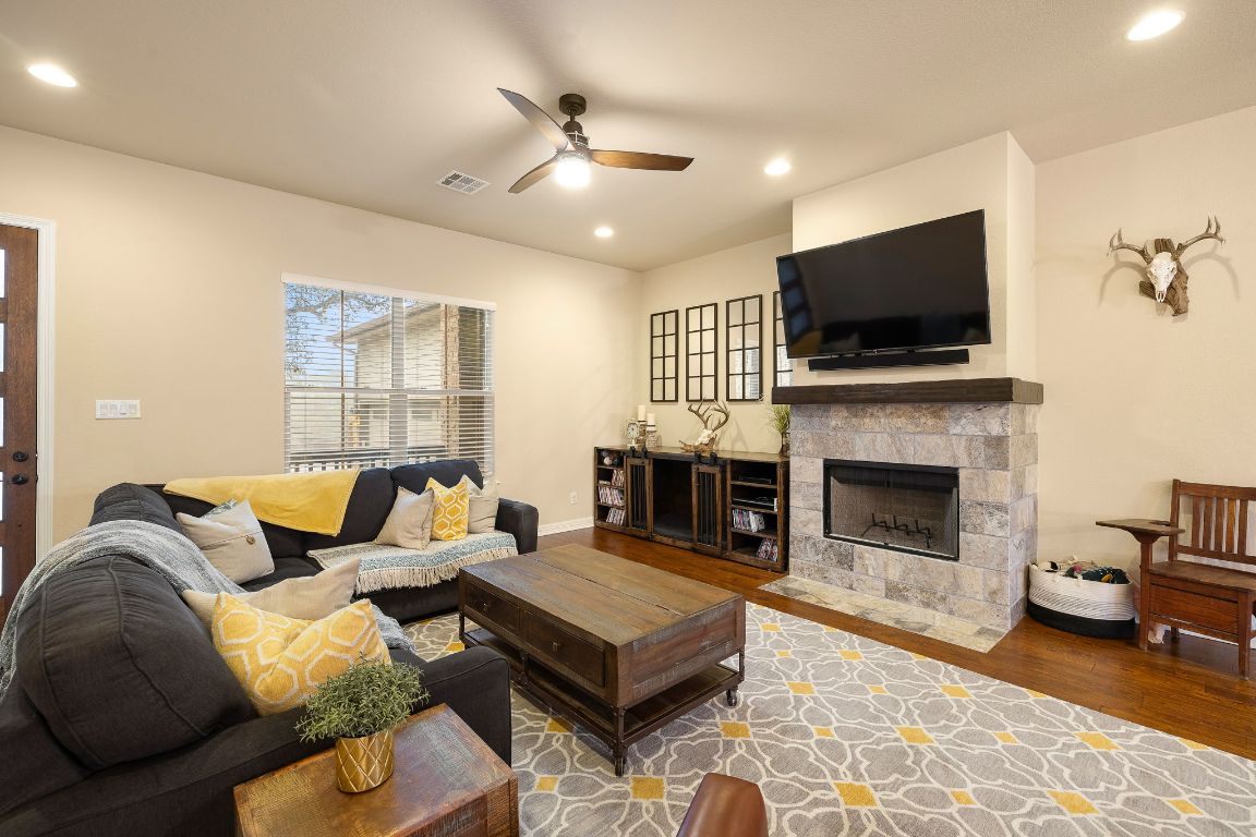 103 Kendall Road Spicewood, TX 78669 - Photo 5 of 37 a living room with furniture a flat screen tv and a fireplace