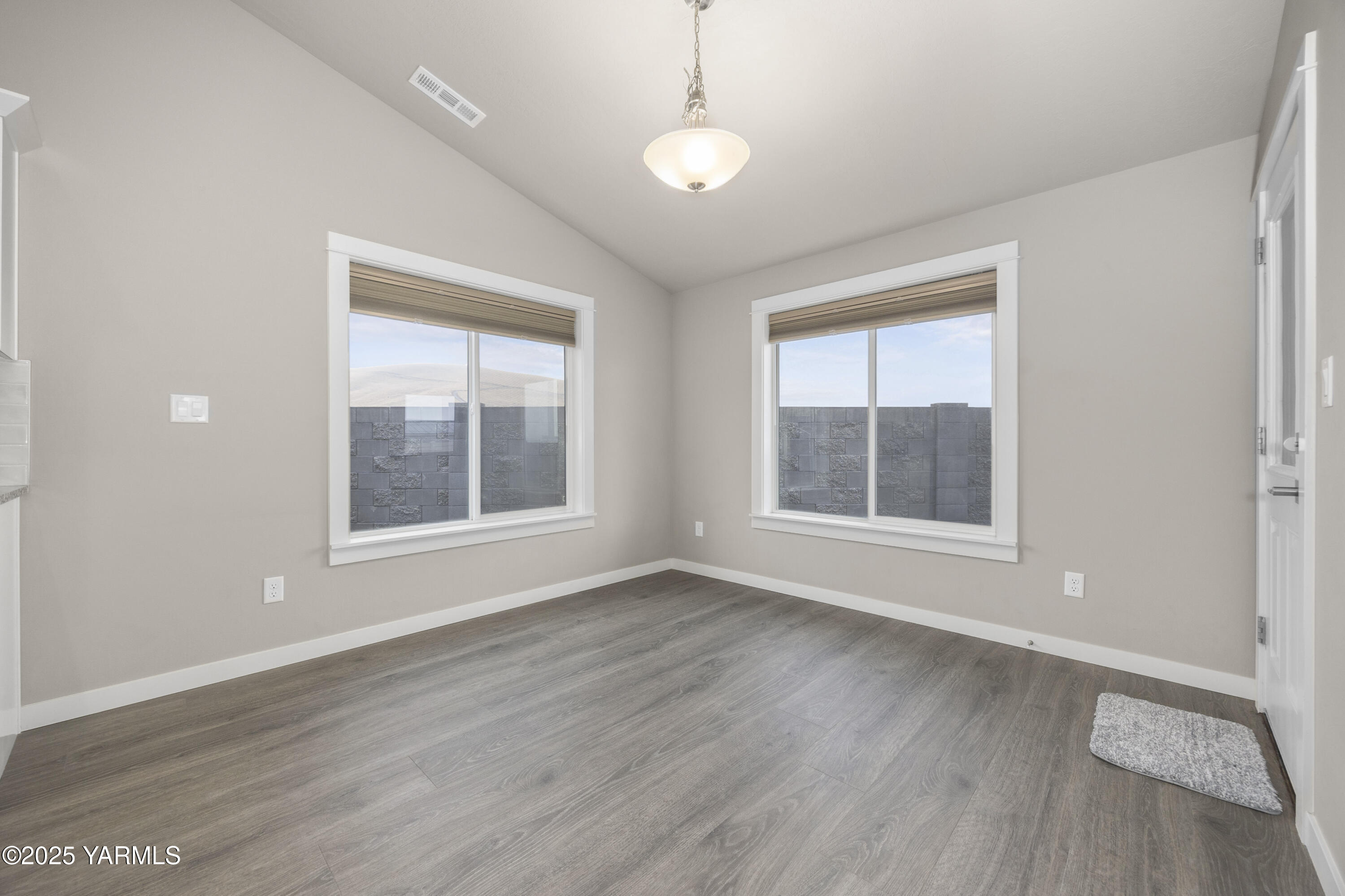 217 Rio Bravo Street Prosser, WA 99350 - Photo 12 of 44 a view of an empty room with wooden floor and a window