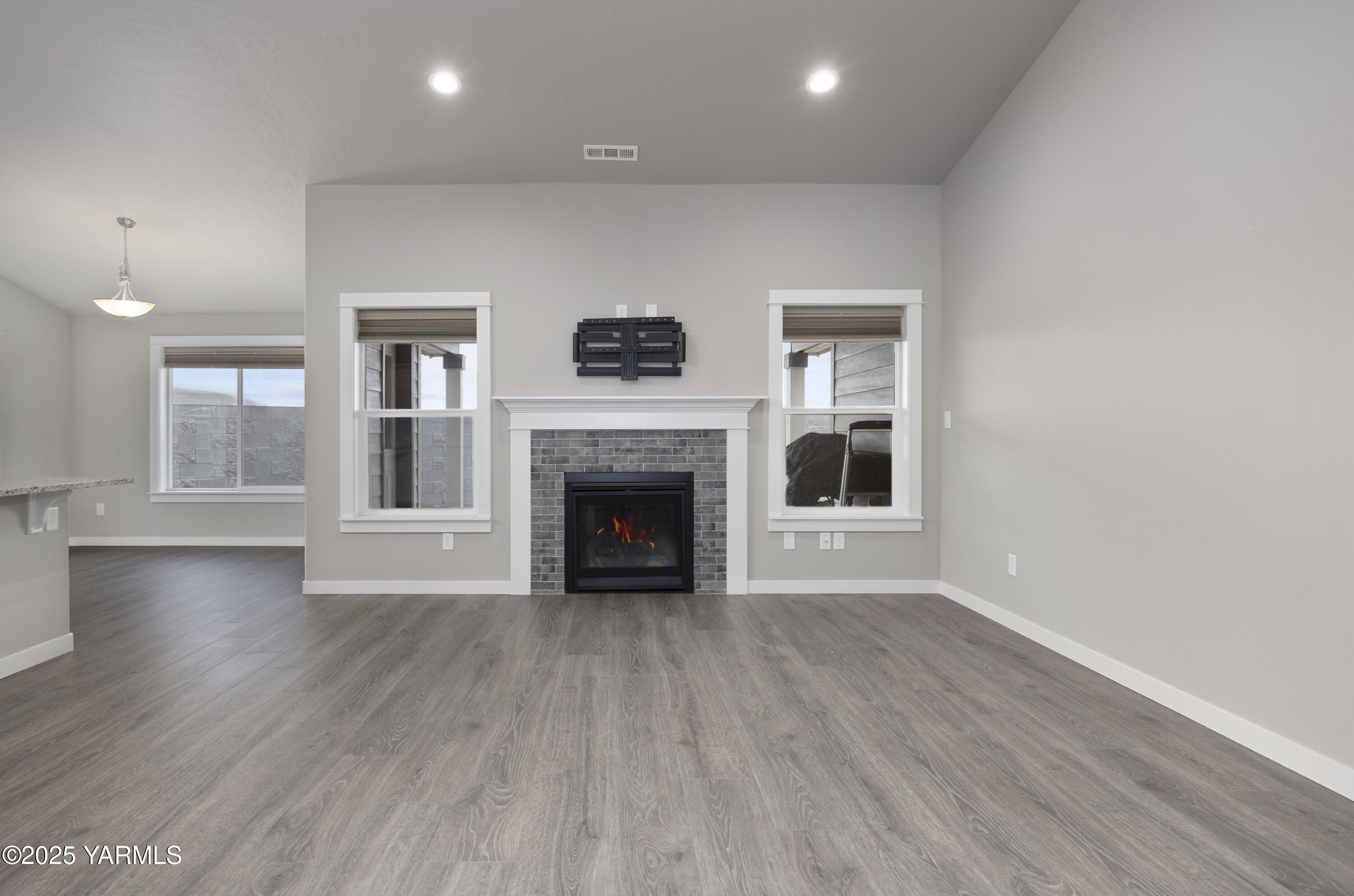 217 Rio Bravo Street Prosser, WA 99350 - Photo 4 of 44 an empty room with wooden floor and a fireplace