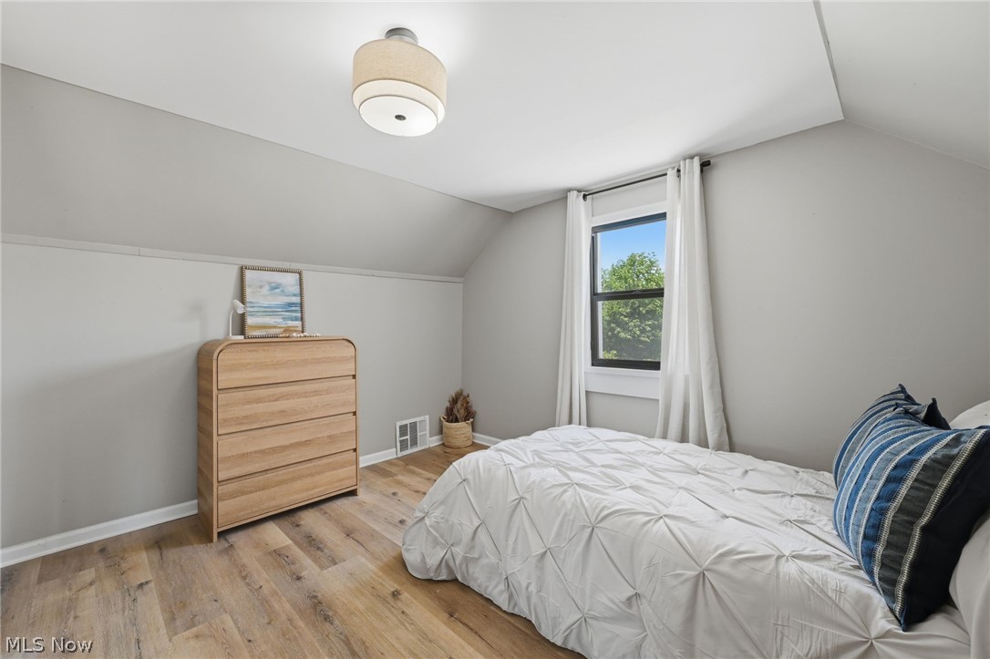 951 Bey Road Akron, OH 44312 - Photo 23 of 34 Second floor bedroom featuring wood-finish flooring, a window with exterior views, light gray wall paint, white trim, and a semi-flush ceiling light fixture