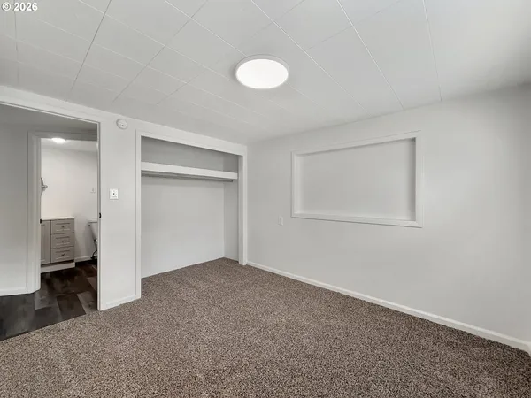 an empty room with closet area and bathroom
