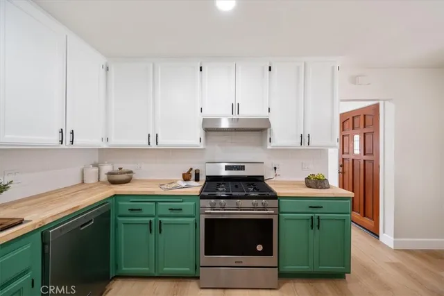 a kitchen with granite countertop a sink a stove and cabinets