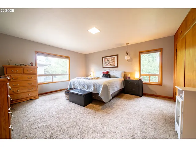 a spacious bedroom with a bed and wooden floor