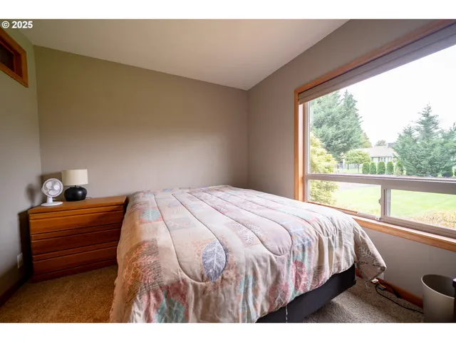 a bedroom with a bed and a large window