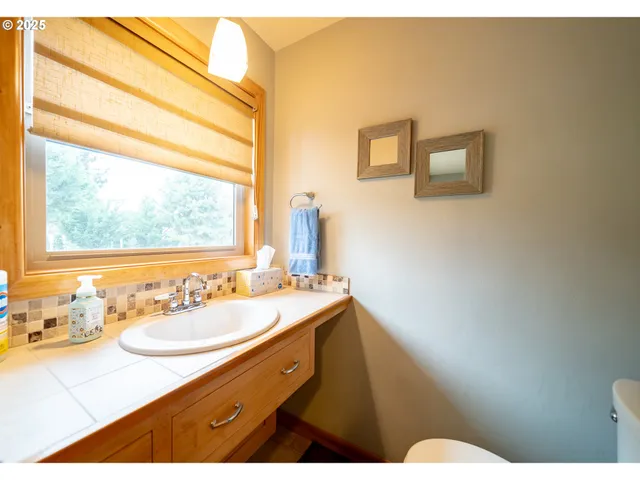 a bathroom with a sink vanity mirror and a toilet