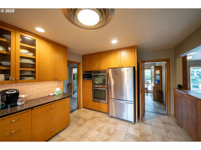 a kitchen with stainless steel appliances granite countertop a refrigerator a stove and a sink