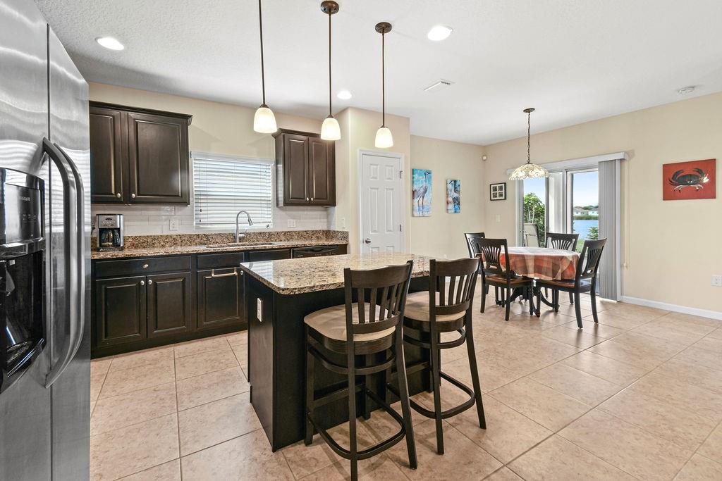 1728 Berkshire Circle Southwest Vero Beach, FL 32968 - Photo 13 of 36 a kitchen with a dining table chairs stainless steel appliances and cabinets