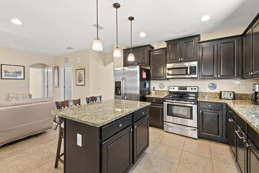 1728 Berkshire Circle Southwest Vero Beach, FL 32968 - Photo 15 of 36 a kitchen with kitchen island a sink stove and refrigerator
