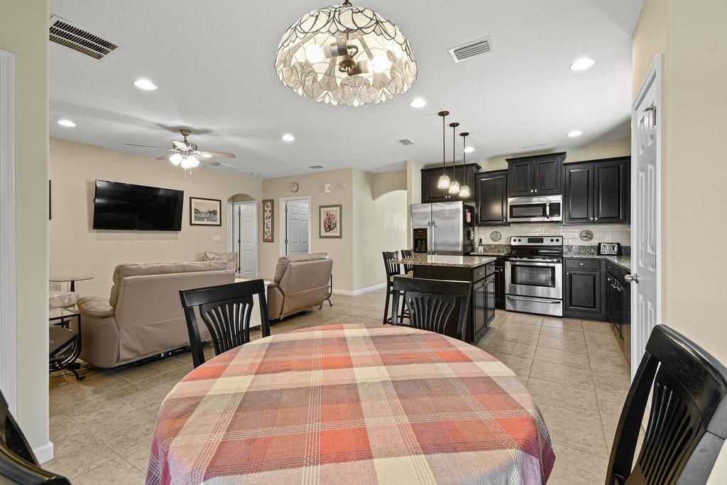 1728 Berkshire Circle Southwest Vero Beach, FL 32968 - Photo 17 of 36 a large kitchen with kitchen island stainless steel appliances a dining table and chairs