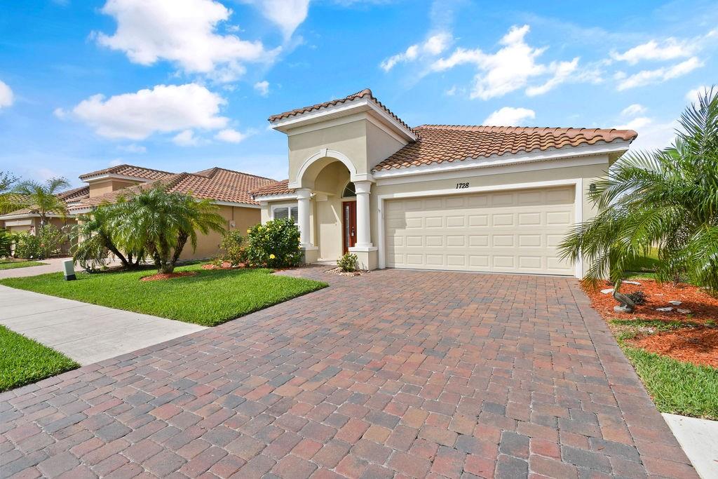 1728 Berkshire Circle Southwest Vero Beach, FL 32968 - Photo 2 of 36 a front view of a house with a yard and garage
